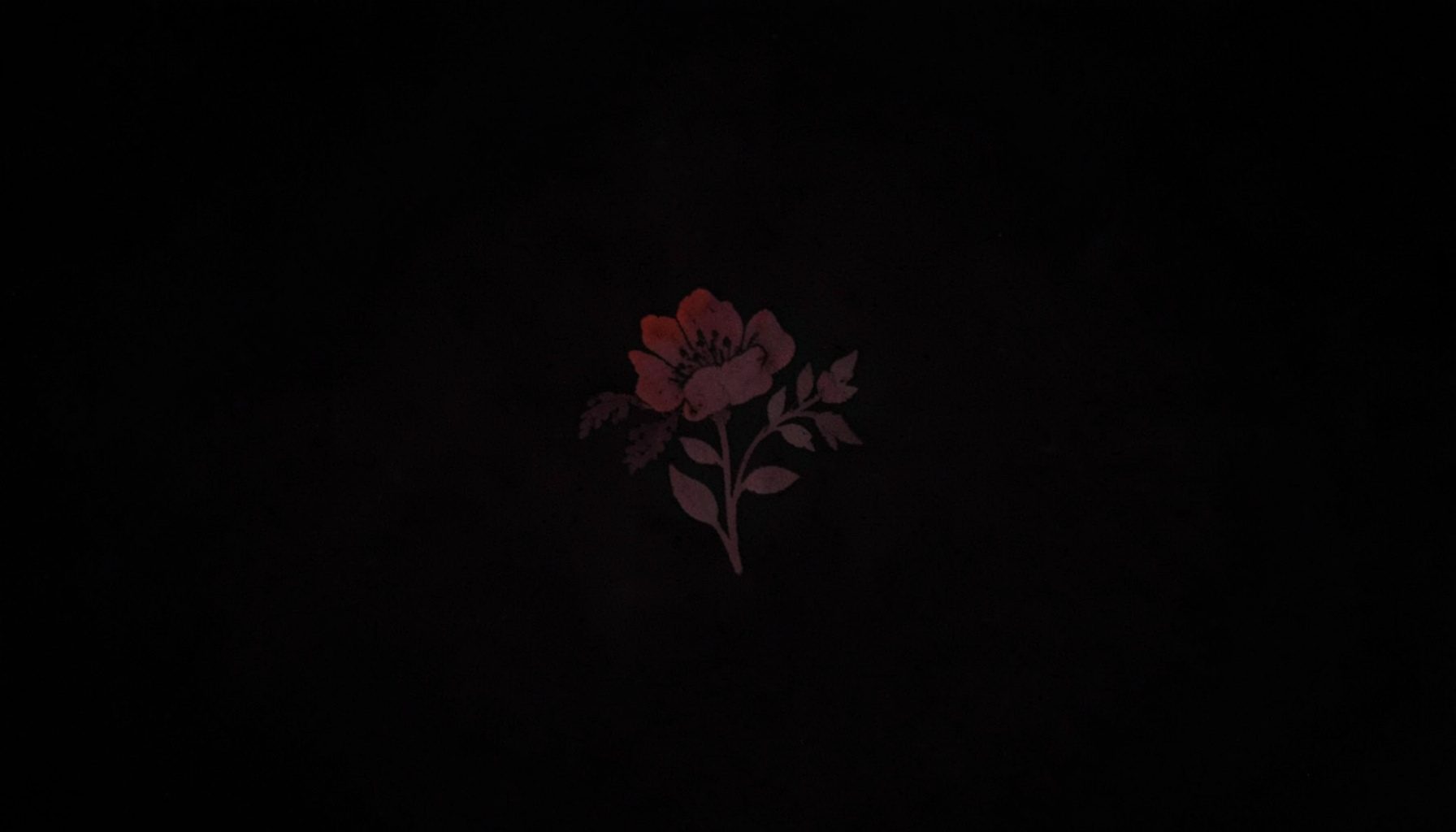 A faint decorative watercolor floral motif in blush and dusty rose used as a simple mark
